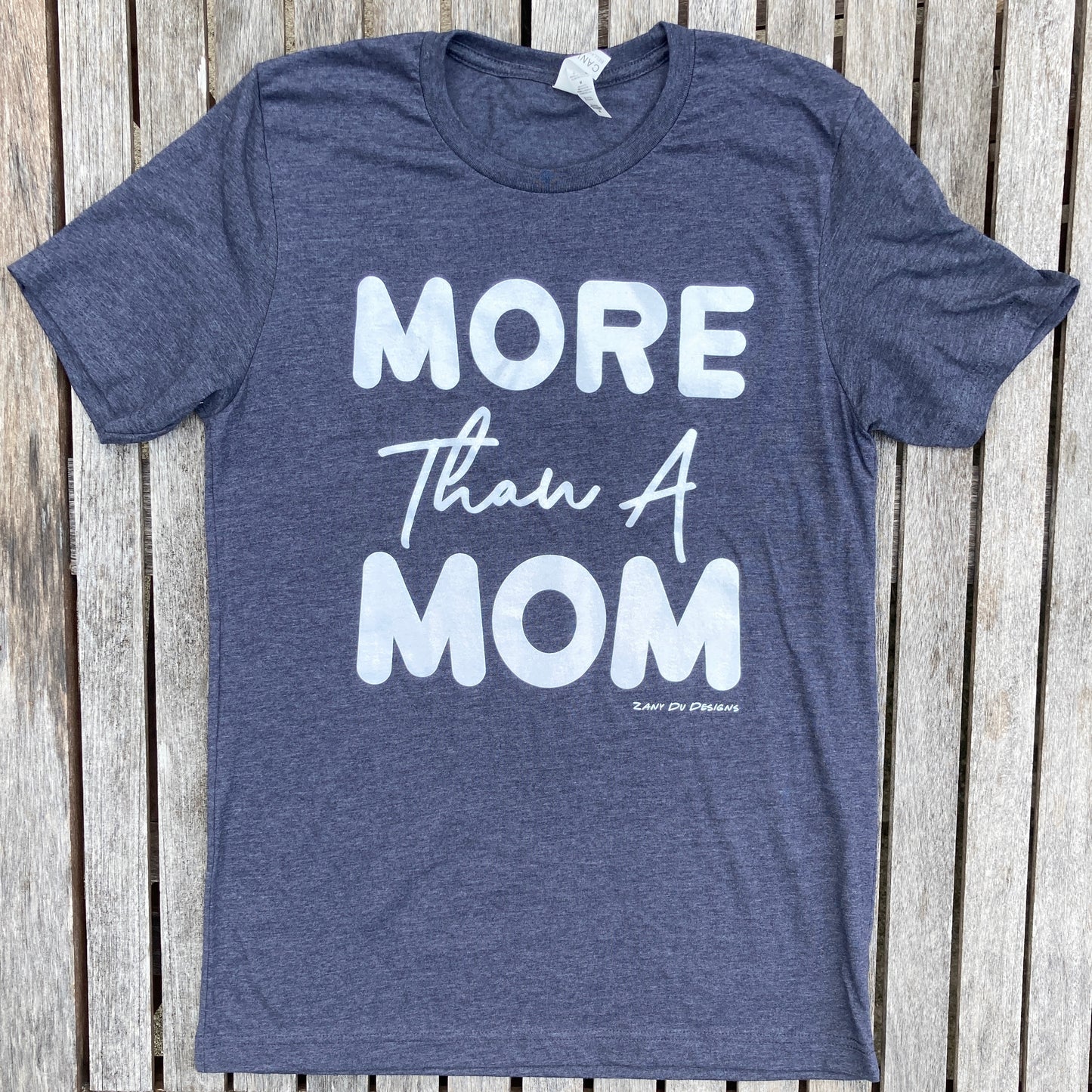 Heather navy sparkle ink tee that has the writing saying, "MORE THAN A MOM" on the front of the tee shirt