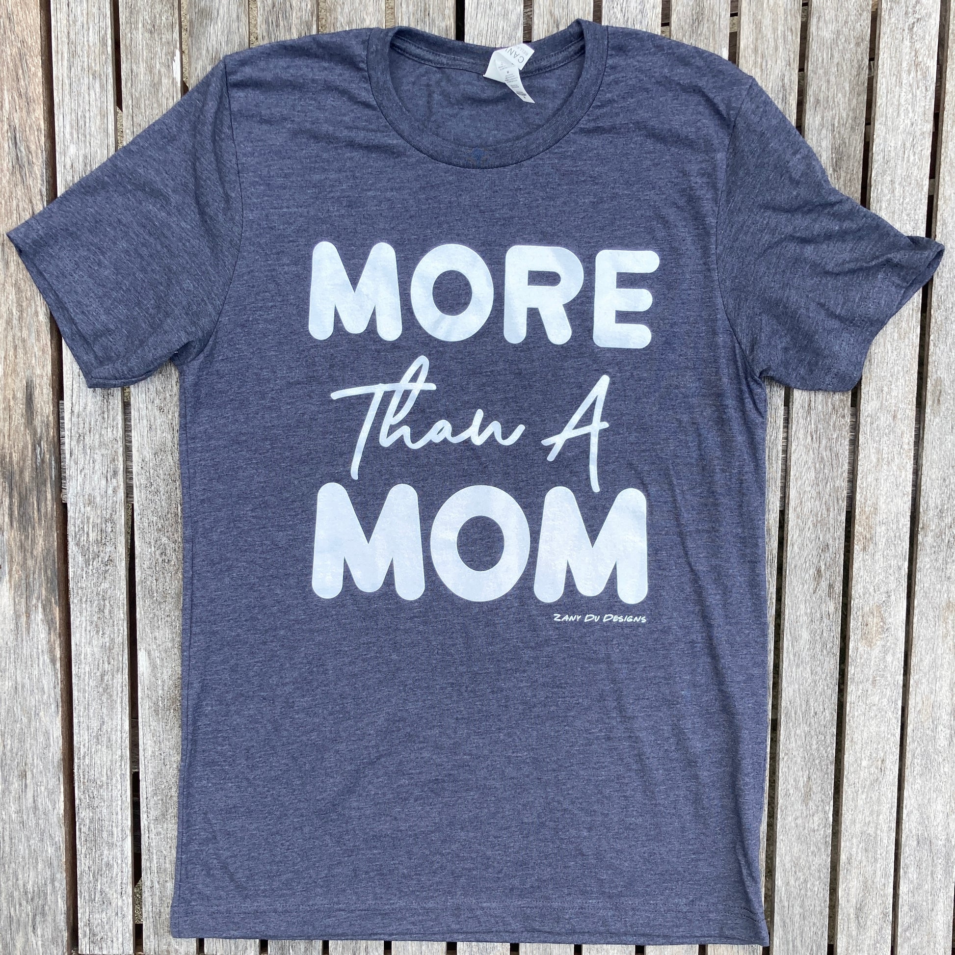 Heather navy sparkle ink tee that has the writing saying, "MORE THAN A MOM" on the front of the tee shirt