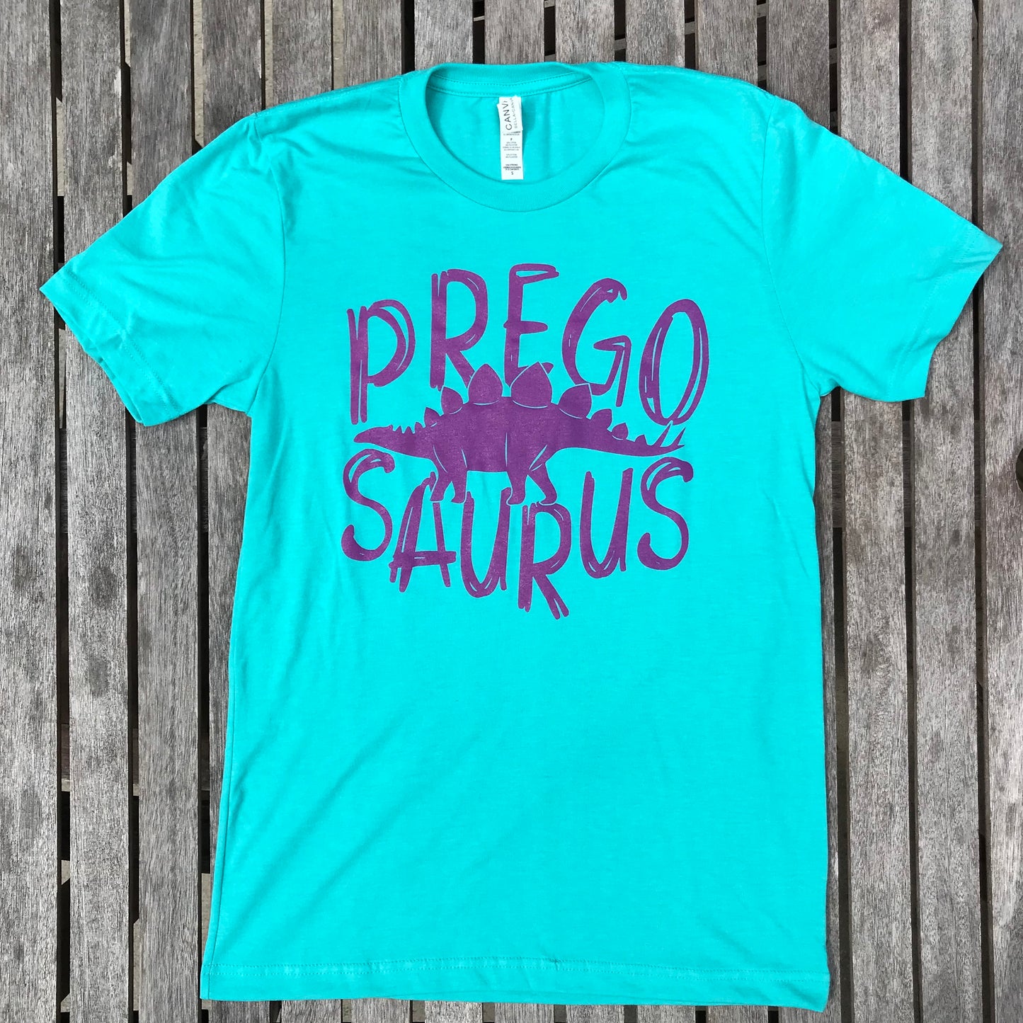 seafoam graphic tee for pregnancy, "Prego Saurus" in purple handwriting and a stegasaurus, boy mom, pregnancy, announcement, new mom, graphic tee