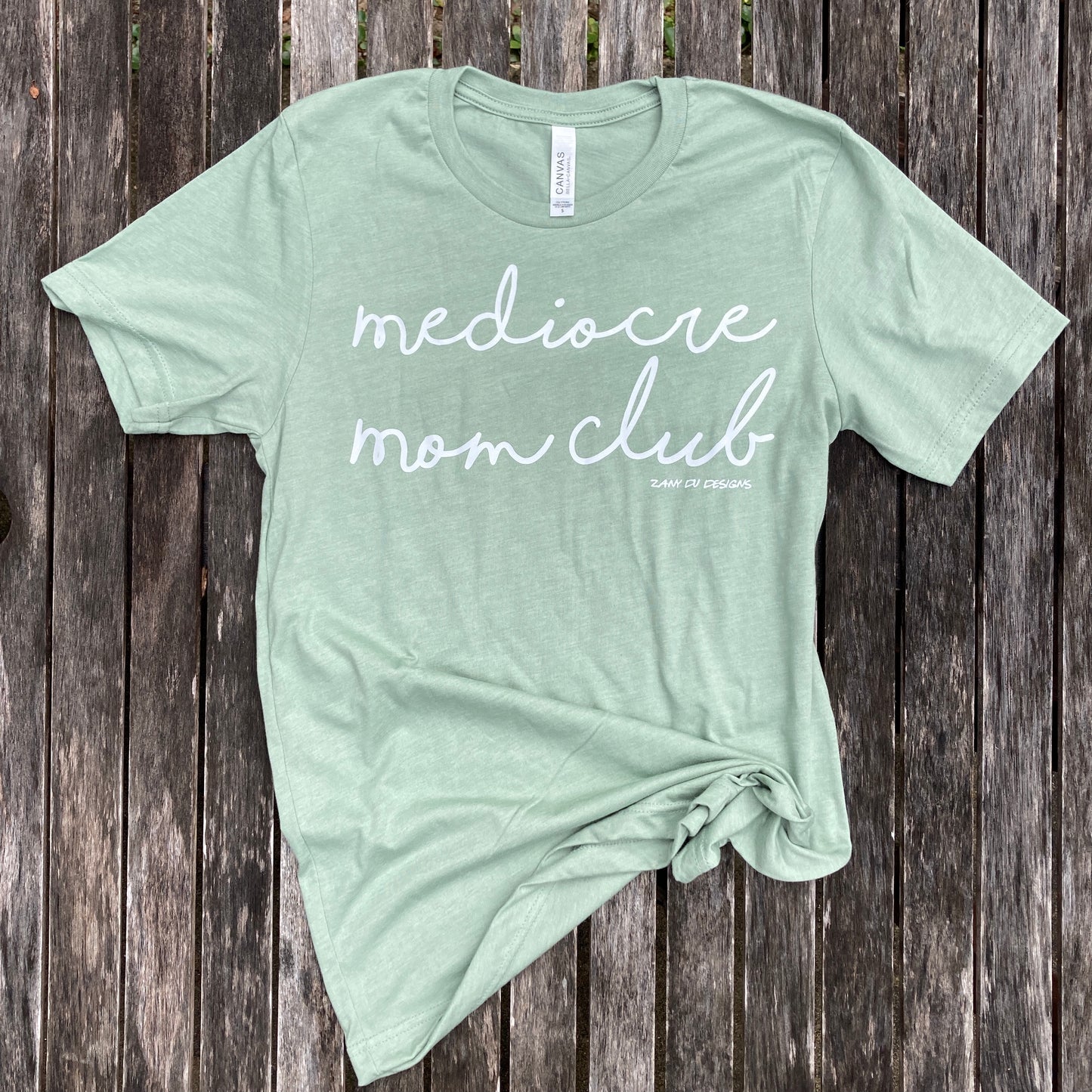 Sage tee that says, "mediocre mom club" in white font for new moms