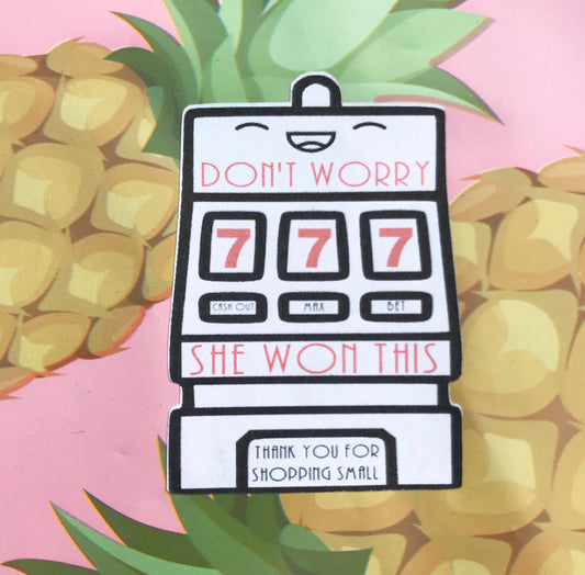 Slot machine sticker that says, "Don't Worry" then has the triple 7 then syas, "SHE WON THIS" and at the very bottom in small font it says, "thank you fro shoppping small"