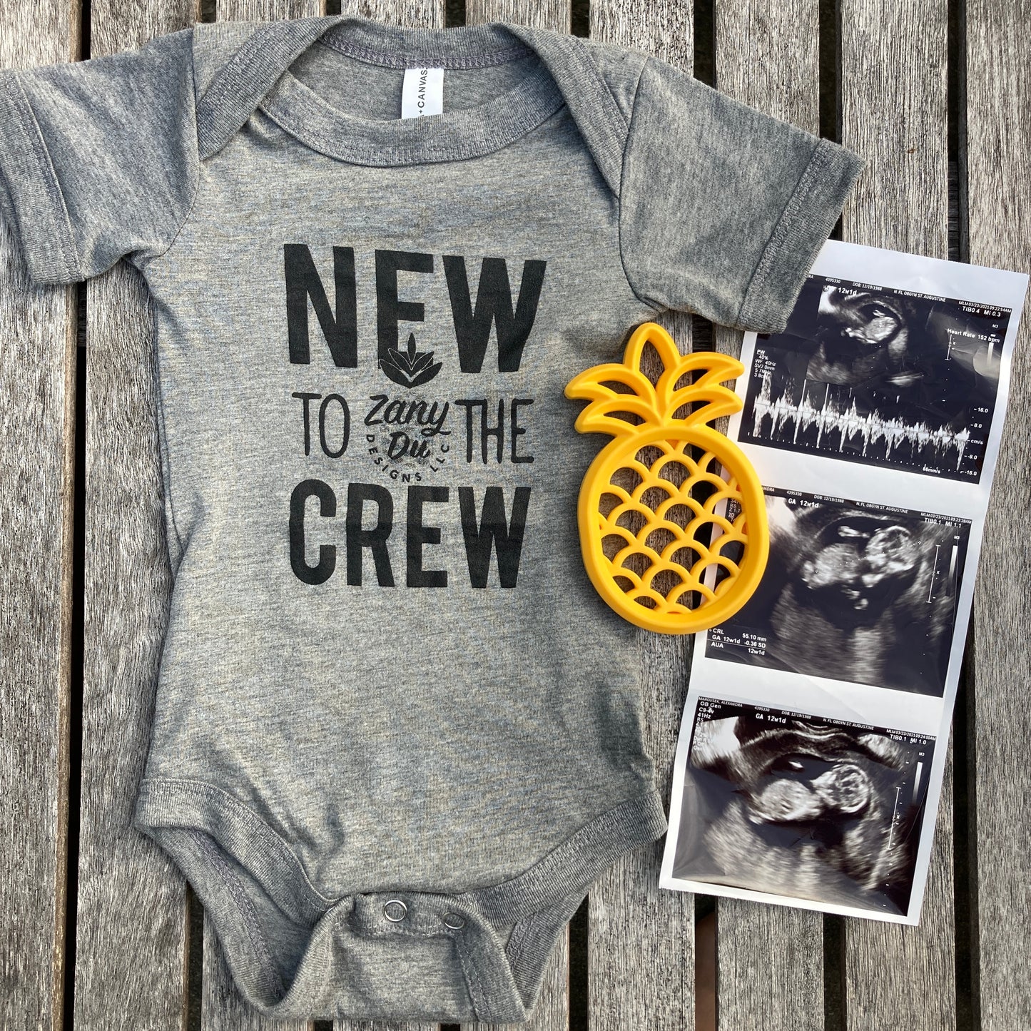 baby bodysuit in grey "new to the crew" contains zanydu logo- picture contains a pineapple teether and 3 ultrasound photos: new to the crew, baby announcement, pregnancy, baby, pregnant, birth announcement, gender reveal, first time mom, it's a...