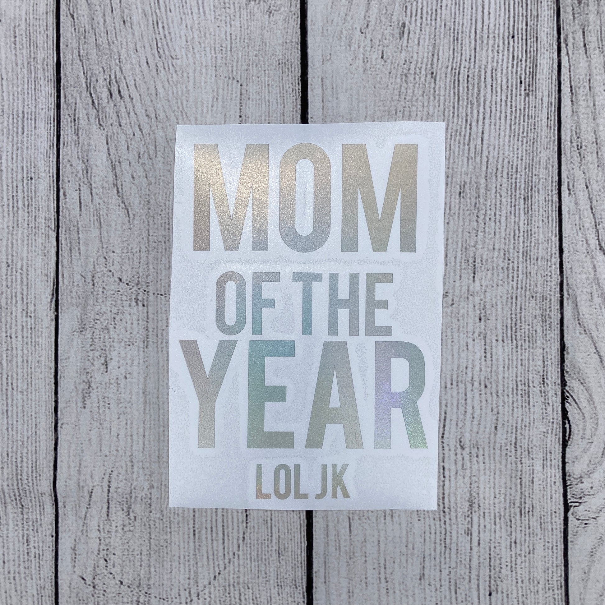 Holographic window car decal that says, "MOM OF THE YEAR JK" with the MOM and YEAR parts having bigger lettering than the other words. - okay mom - mediocre mom - motherhood -  car decal