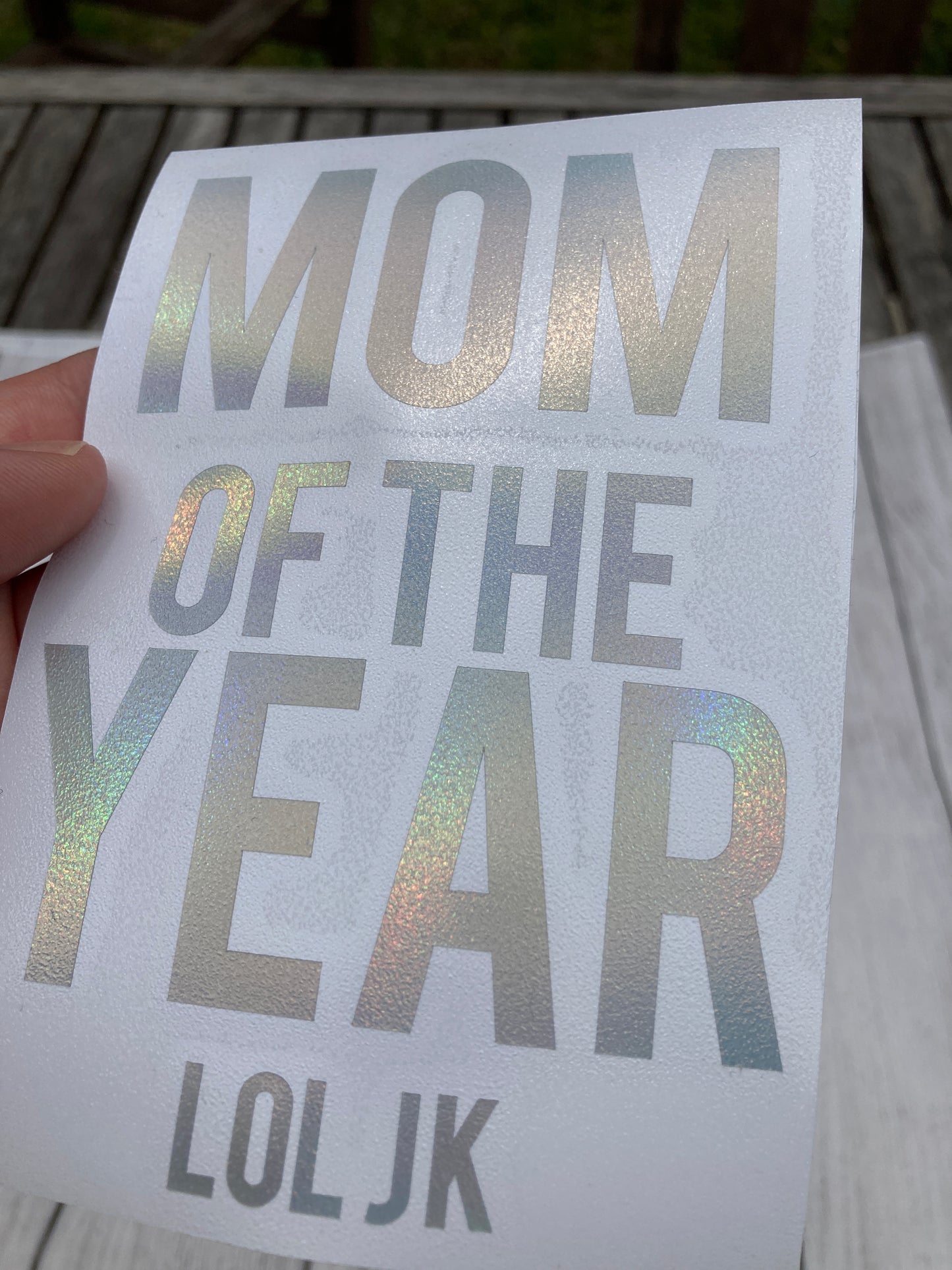 Holographic window car decal that says, "MOM OF THE YEAR JK" with the MOM and YEAR parts having bigger lettering than the other words. - okay mom - mediocre mom - motherhood - car decal