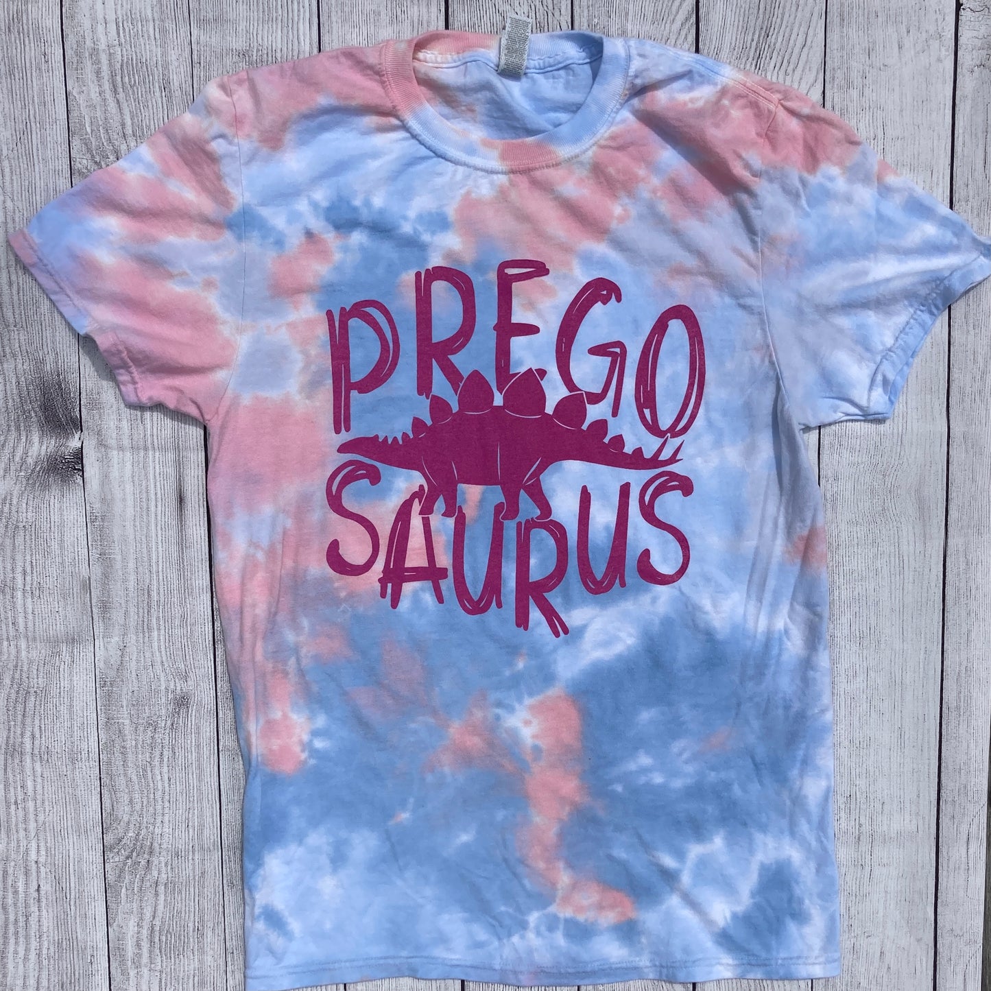 pink and blue tie dye tee that says, "PREGO SAURUS" with a dino inbetween the 2 words - maternity - pregnant - dino - tie dye -graphic tee