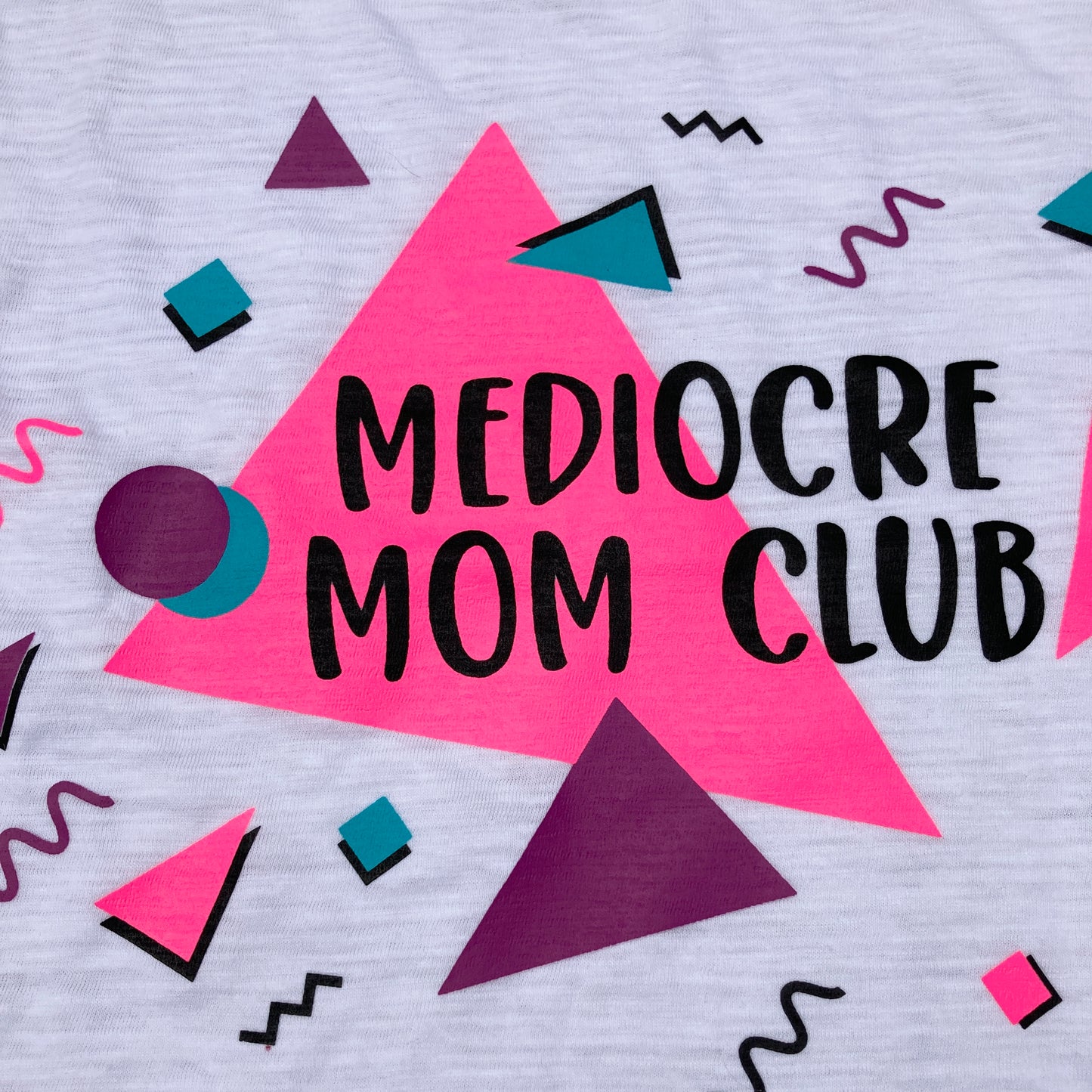 Shirt Design saying, "MEDIOCRE MOM CLUB" - 90's - Retro - Pink, Purple, and Blue font colors.