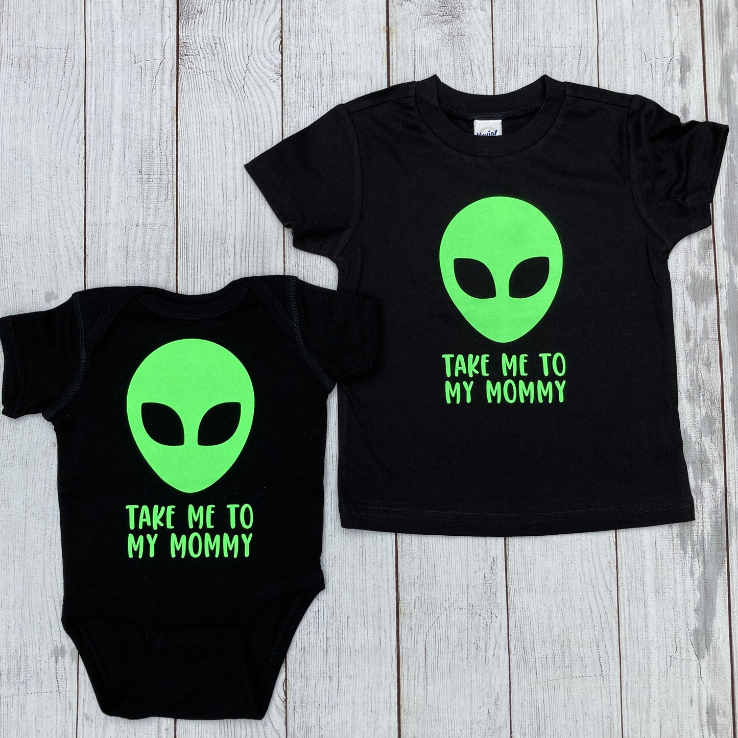 black tee with writing saying, "TAKE ME TO MY MOMMY", a lime green alien, font is limegreen - graphic tee -