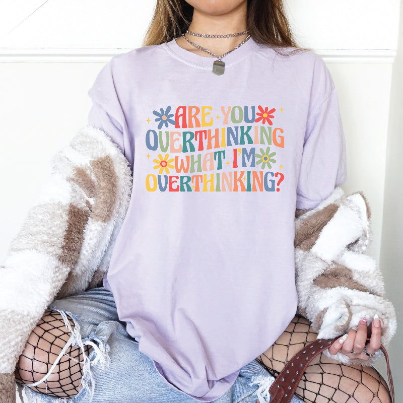 woman wearing a purple tshirt that reads are you overthinking what im overthinking in cute and colorful text. 