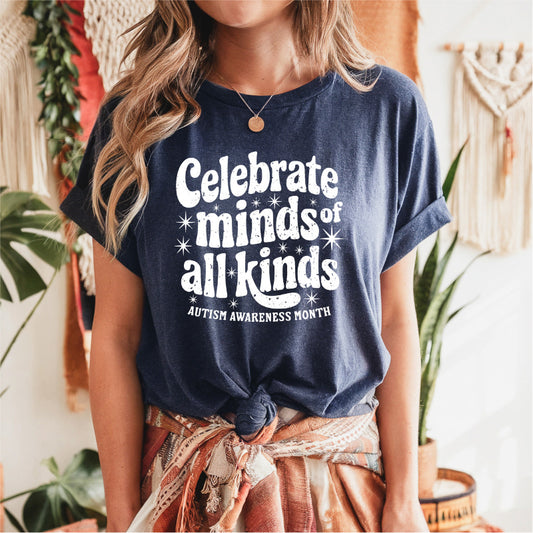 Person wearing a navy blue t-shirt with 'Celebrate minds of all kinds' text, standing in a home setting.