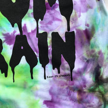 Green and purple tie dye with the writing saying, "BLAME IT ON THE MOM BRAIN" and the MOM BRAIN part has a slime font