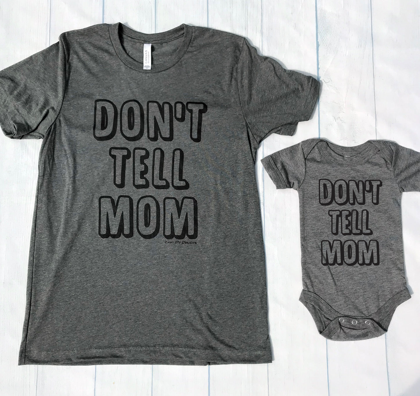 Grey don't tell mom toddler t-shirt with the writing saying, "DON'T TELL MOM"