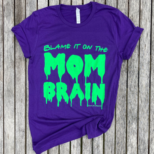 Slime purple and neon green tee with the writing saying, "BLAME IT ON THE MOM BRAIN" and the MOM BRAIN part has a slime font - Brain - Spooky - Halloween