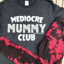 Black mummy club tee shirt with the writing saying, "MEDIOCRE MUMMY CLUB" 'Mummy' in a mummy wrapped font.